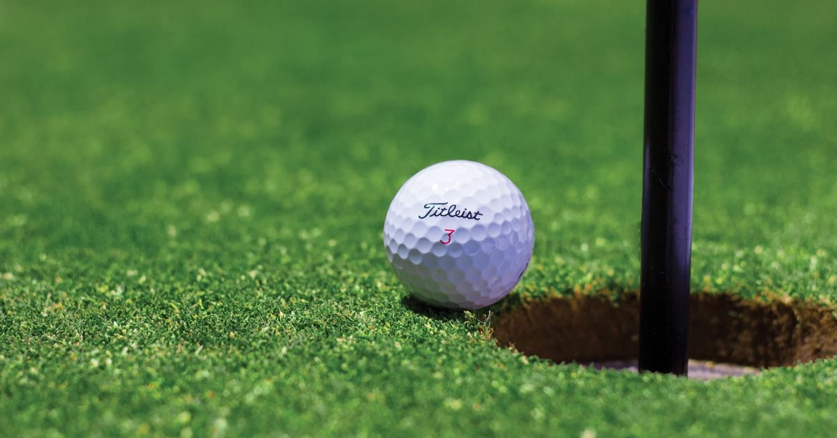 A golf ball just missing the hole to give a bogey golf score