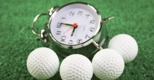 A picture of a golf round timer next to golf balls.